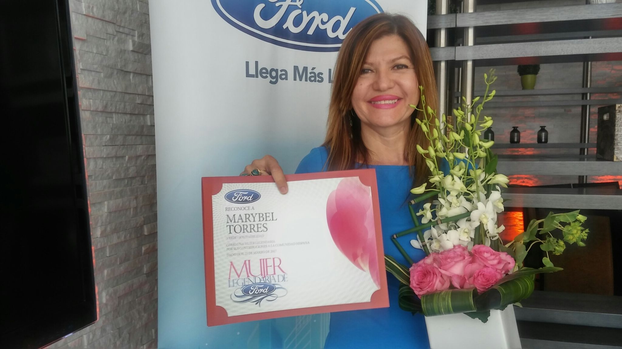 Marybel Torres muestra feliz y orgullosa su diploma de reconocimiento.