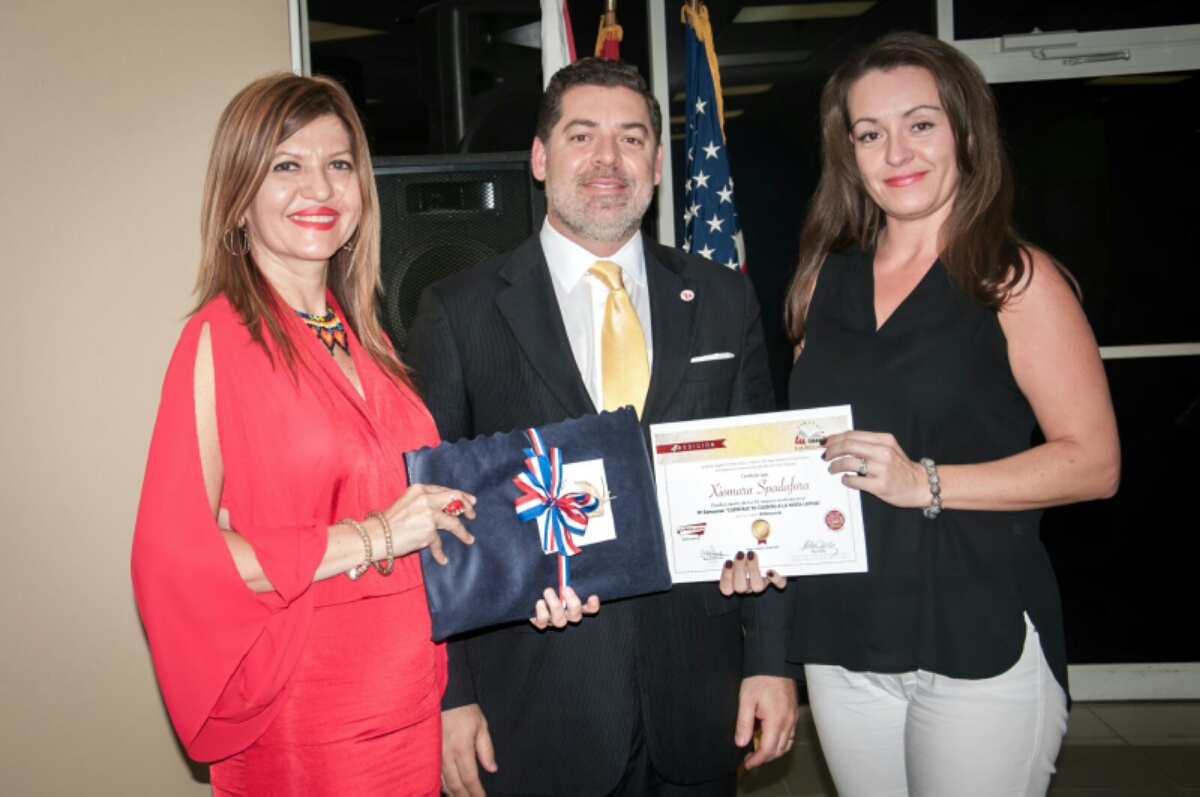 La escritora Xiomara Spadafora recibe reconocimiento de Marybel Torres y Carlos Montes de Oca como finalista del concurso.