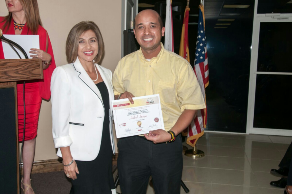 El escritor Aníbal Anaya recibe su reconocimiento como ganador de la categoría "Cuenta Sin Cuenta", por parte de Ivonne Fernández, directora de AARP Florida.