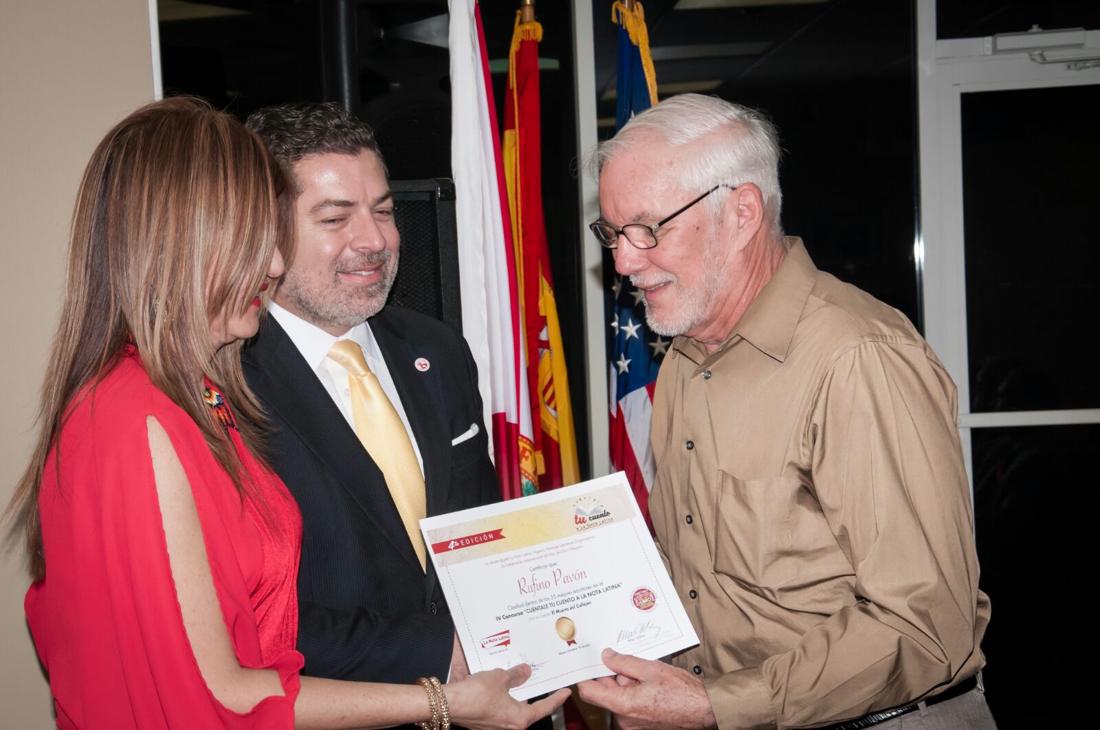 El escritor Rufino Pavón recibe de Marybel Torres y Carlos Montes de Oca su reconocimiento como finalista del concurso.