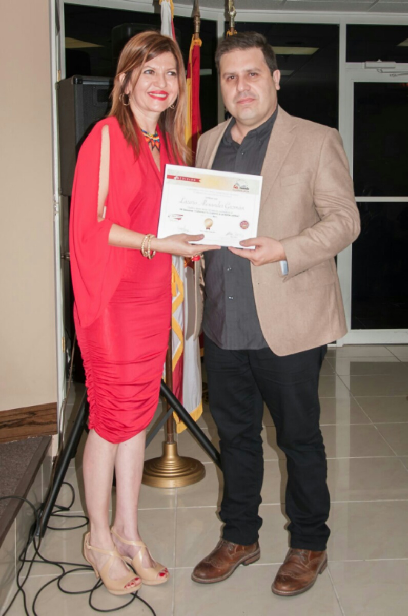 El escritor Lázaro Guzmán recibe de Marybel Torres su reconocimiento como finalista del concurso.