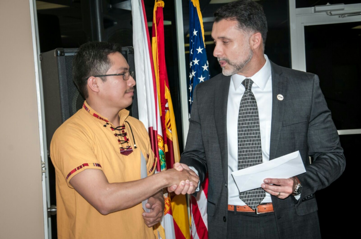Luis Xalin, ganador del primer lugar, recibe de Luis Guillermo Castillo, gerente de comercial de la aerolínea PAWA sus boletos para viajar a República Dominicana.